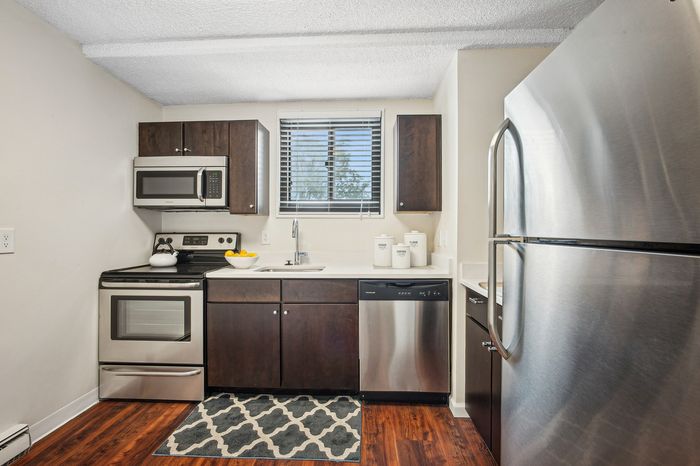 Modern kitchen with stainless steel appliances, elegant dark wood cabinetry, and a bright, welcoming atmosphere.