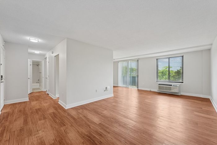Bright and spacious apartment interior with elegant wooden flooring, large windows, and modern design.