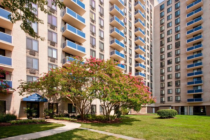Charming apartment building with modern balconies and beautifully landscaped gardens, offering a serene and pleasant environment.