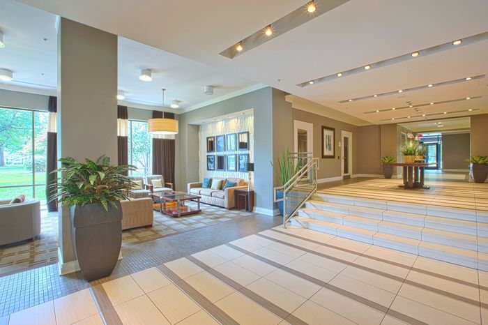 Elegant apartment lobby featuring modern seating, plush decor, and large windows offering scenic views.