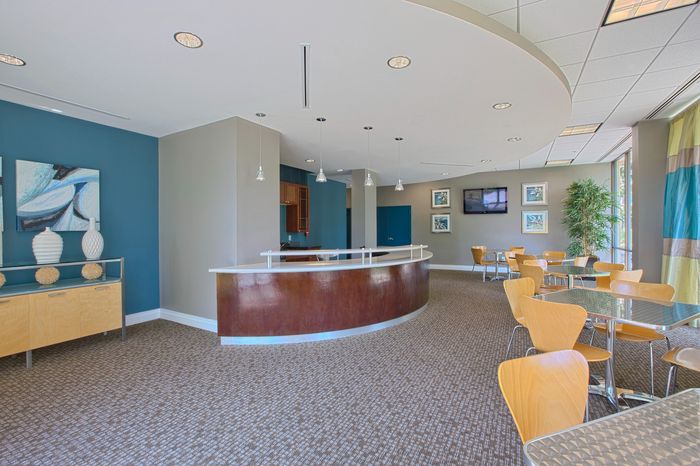 Elegant community lounge with a sleek modern counter, vibrant decor, and natural light, perfect for gatherings.