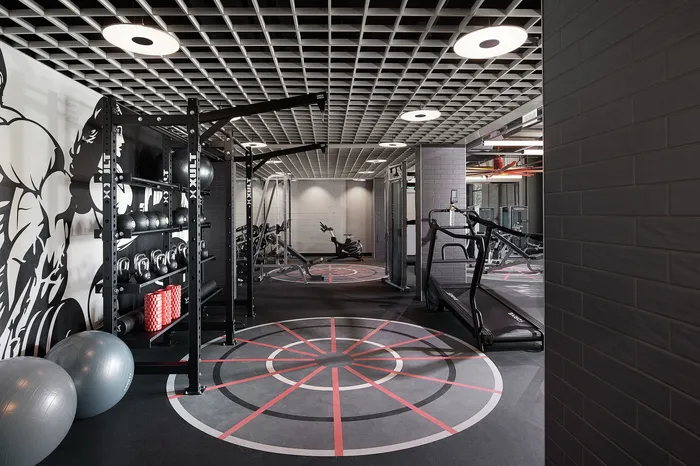 Modern fitness center with cutting-edge equipment, including treadmills, weight racks, and exercise balls, set in a sleek industrial design.