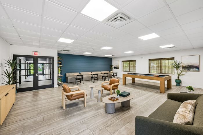 Modern recreation room featuring sleek furniture, cozy seating, and a billiard table, perfect for relaxation and social gatherings.