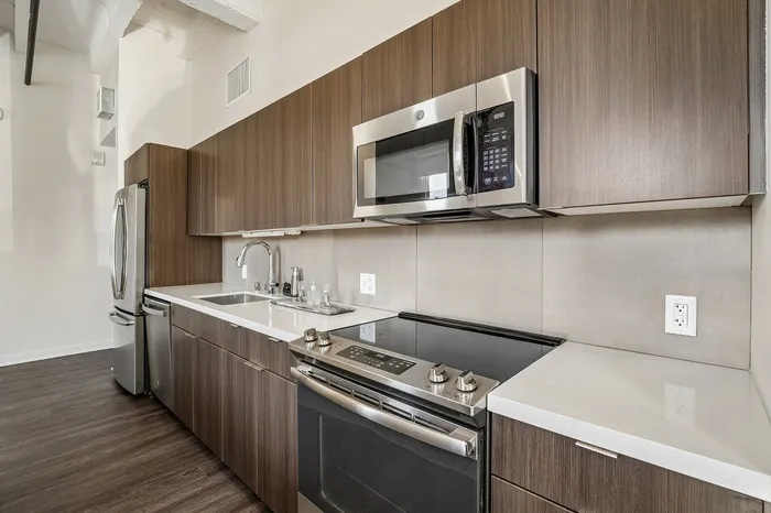 Modern kitchen with sleek stainless steel appliances, stylish wood cabinets, and elegant countertops.