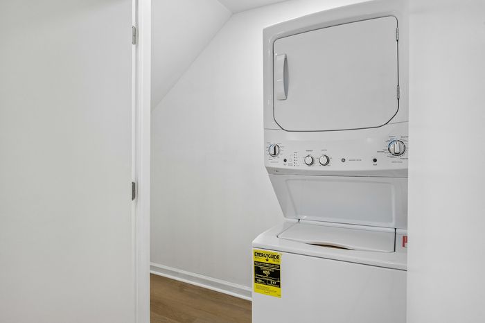 Efficient in-unit laundry area featuring a sleek, stacked washer and dryer for modern convenience.