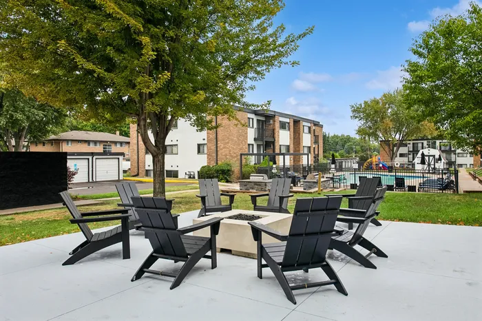 Chic apartment complex with modern outdoor seating, lush green landscaping, and an inviting pool area.