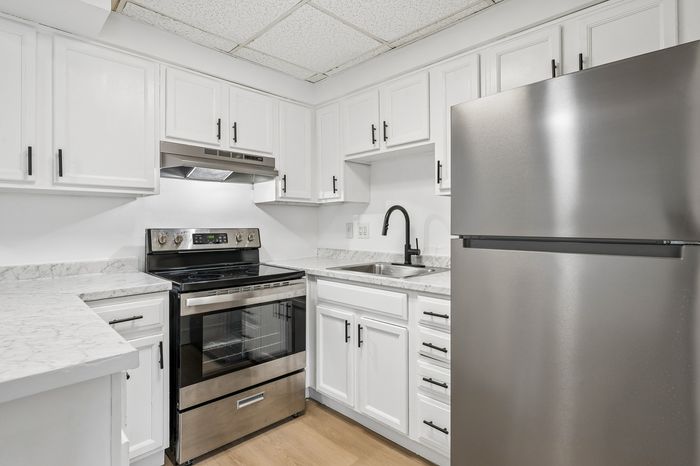 Modern kitchen with sleek stainless steel appliances, chic white cabinetry, and elegant marble countertops.