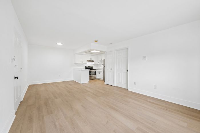 Bright and airy open-concept living space with sleek hardwood floors and a contemporary kitchen.