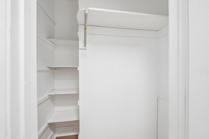 Bright, organized walk-in closet with ample shelving and storage space, perfect for a neat and tidy home.
