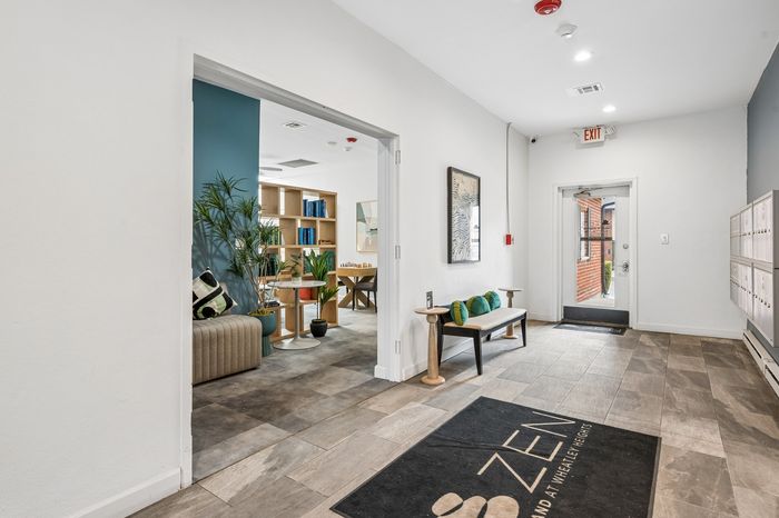 Inviting apartment entrance with cozy seating area, stylish decor, and natural light showcasing a welcoming space.