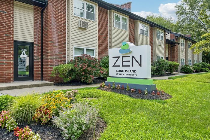 Serene Zen Long Island apartment building featuring modern design with lush landscaping and vibrant greenery at Wheatley Heights.