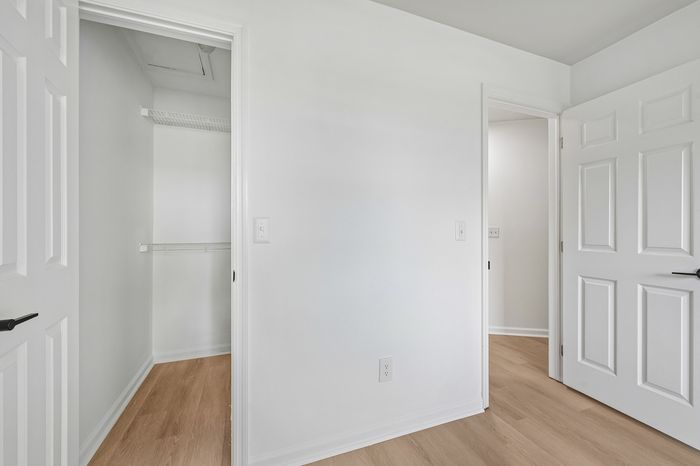 Bright and airy walk-in closet with clean white walls and modern shelving, perfect for stylish organizational solutions.