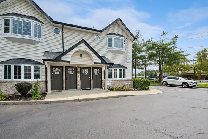 Charming duplex building with modern bay windows and a welcoming entryway, perfect for family living in a serene neighborhood.