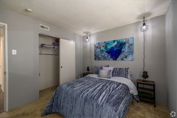 Charming bedroom featuring stylish bedding, modern wall art, and elegant pendant lighting.