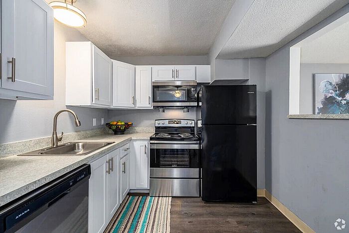 Modern kitchen with sleek white cabinetry, stainless steel appliances, and a spacious countertop, perfect for culinary enthusiasts.