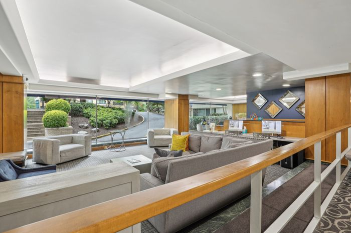 Stylish and inviting lobby featuring modern decor, plush seating, and large windows offering lush garden views.