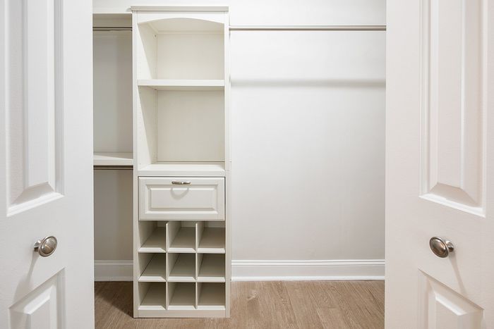 Elegant walk-in closet with built-in shelving, drawers, and a wine rack, offering ample storage space.