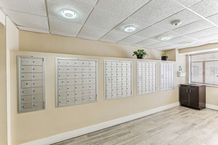 Modern apartment lobby featuring sleek mailboxes, bright lighting, and decorative plants for a welcoming ambiance.