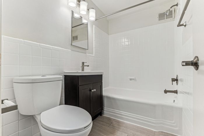 Contemporary bathroom featuring sleek fixtures, pristine white tiles, and a modern vanity.