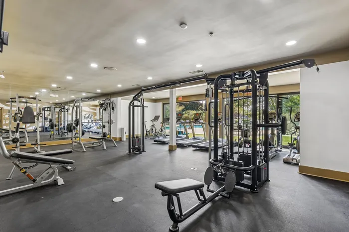 Spacious and modern fitness center with state-of-the-art exercise equipment and large windows offering scenic views.