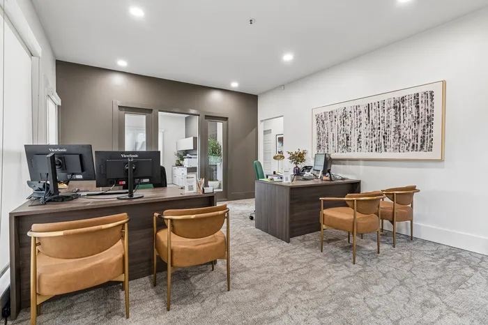 Stylish office space featuring modern workstations, elegant seating, and contemporary decor with a nature-inspired artwork.