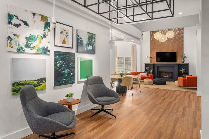 Chic living room with modern artwork, cozy seating, and a warm fireplace creating a stylish and inviting atmosphere.