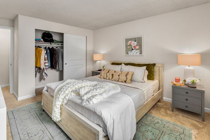 Inviting bedroom with cozy double bed, stylish wall art, and ample closet space, enhanced by soft lighting and elegant decor.