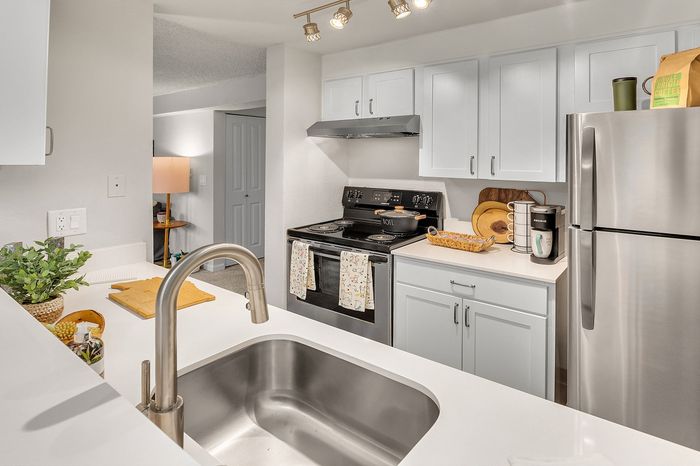 Modern kitchen with sleek stainless steel appliances, elegant white cabinetry, and an inviting open-plan design.