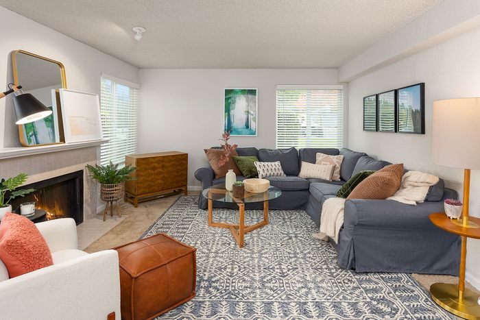 Inviting living room with cozy gray sectional, elegant decor, and a warm fireplace, perfect for relaxation and entertaining.