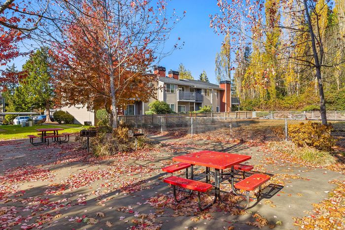 Charming apartment complex with vibrant autumn foliage and inviting picnic area, perfect for outdoor gatherings.
