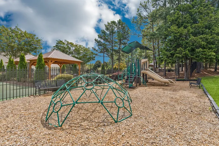 Inviting outdoor playground with modern equipment, nestled among lush trees, offering a perfect family-friendly retreat.