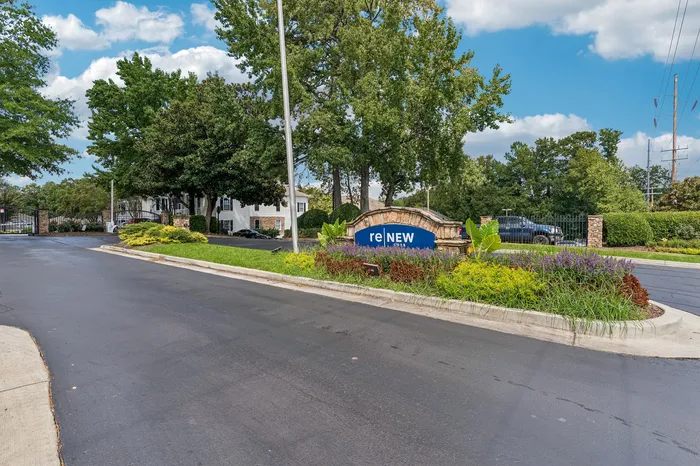 Charming apartment entrance surrounded by lush greenery and inviting landscapes, showcasing the Renew community's welcoming atmosphere.