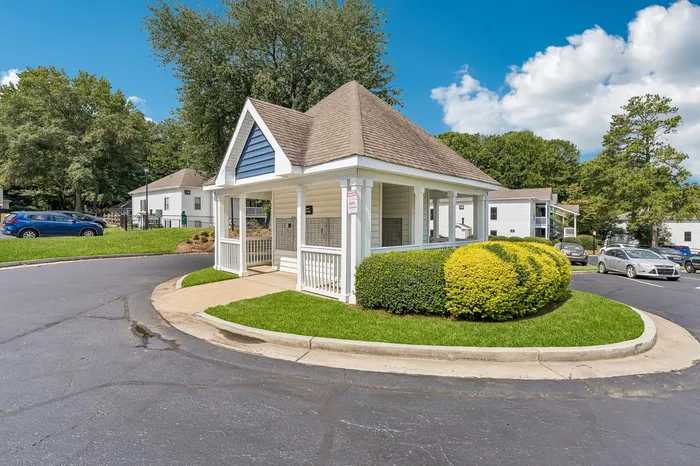 Charming community pavilion with inviting landscaping, surrounded by lush greenery and modern homes.