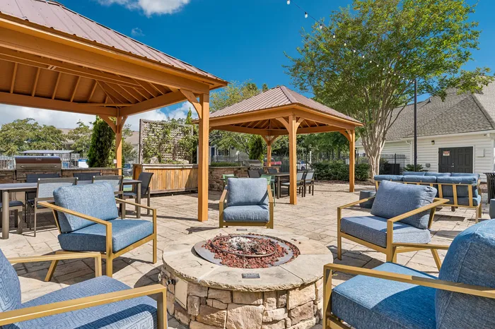 Inviting outdoor patio with cozy seating, stylish gazebos, and a central fire pit, perfect for entertainment and relaxation.