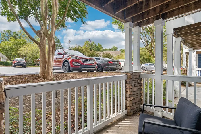 Charming porch view with cozy seating area and lush greenery, offering a relaxing outdoor retreat.