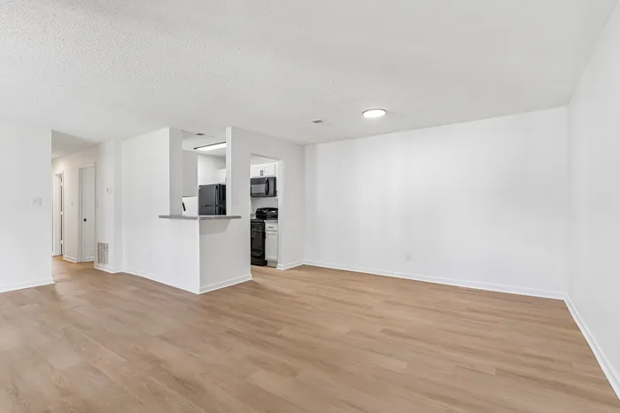Bright, open-concept living space with modern kitchen and elegant wood flooring, perfect for stylish urban living.