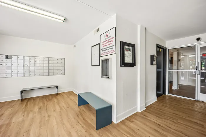 Modern apartment lobby with sleek mailboxes, inviting benches, and elegant wood flooring.