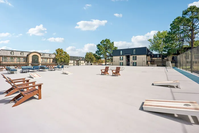 Expansive recreational area with modern seating, outdoor games, and scenic views of the stylish apartment complex.