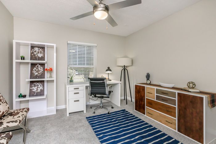 Chic home office featuring a modern desk and chair, elegant decorative shelving, and stylish lighting, creating the perfect workspace.