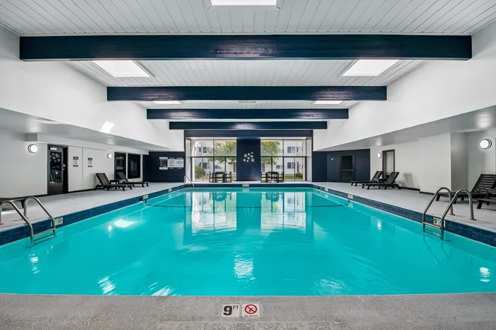 Inviting indoor swimming pool with sleek design and spacious lounge area, ideal for relaxation and leisure.