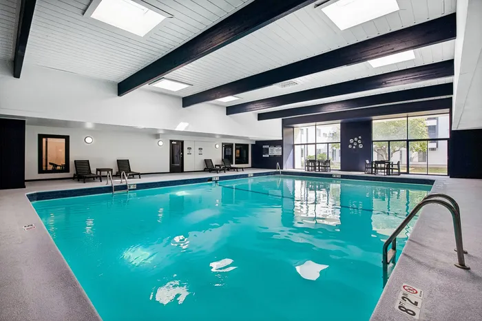 Luxurious indoor swimming pool with modern skylights and spacious lounging area, perfect for relaxation and entertaining.