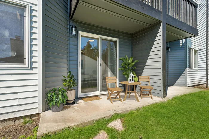 Charming patio with stylish wooden chairs and lush greenery, perfect for outdoor relaxation.