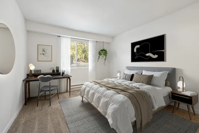 Bright and inviting bedroom with minimalist decor, plush bedding, and a stylish desk by the window.