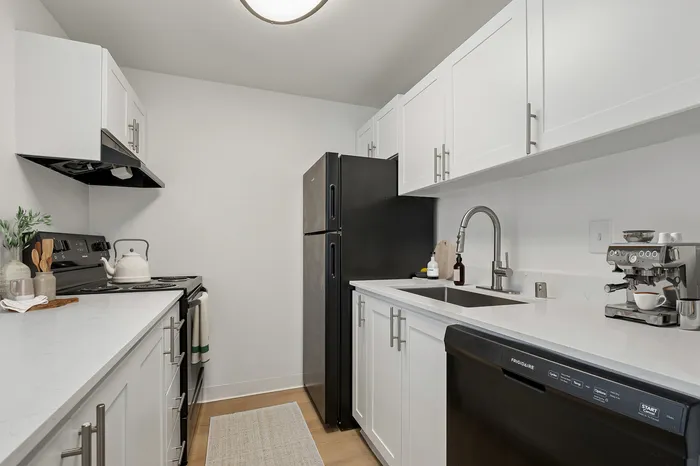 Charming modern kitchen with sleek white cabinetry, stainless steel appliances, and a cozy layout perfect for culinary creativity.