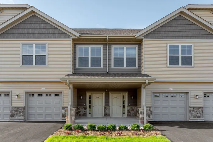 Exterior view of High Bluff Townhomes in Grafton, Wisconsin showcasing the apartment buildings and community layout.