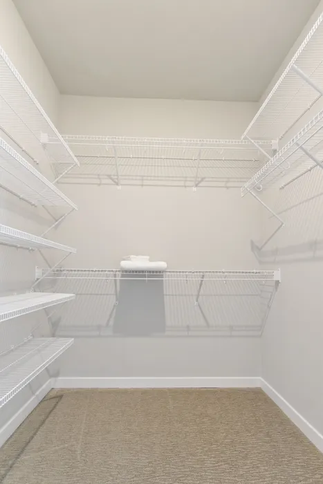 Walk-in closet at Seasons at North Aurora Apartments in North Aurora, Illinois providing organized storage space.