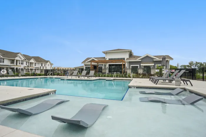 Resort-style pool at Seasons at Franklin Apartments in Franklin, Wisconsin featuring seating areas and space to relax outdoors.
