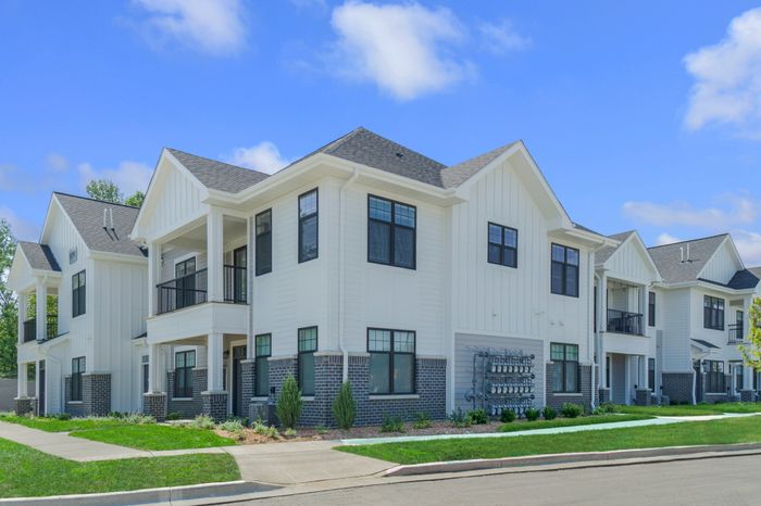 Resident building exterior at Seasons at Franklin Apartments in Franklin, Wisconsin featuring private entries and attached garage access.