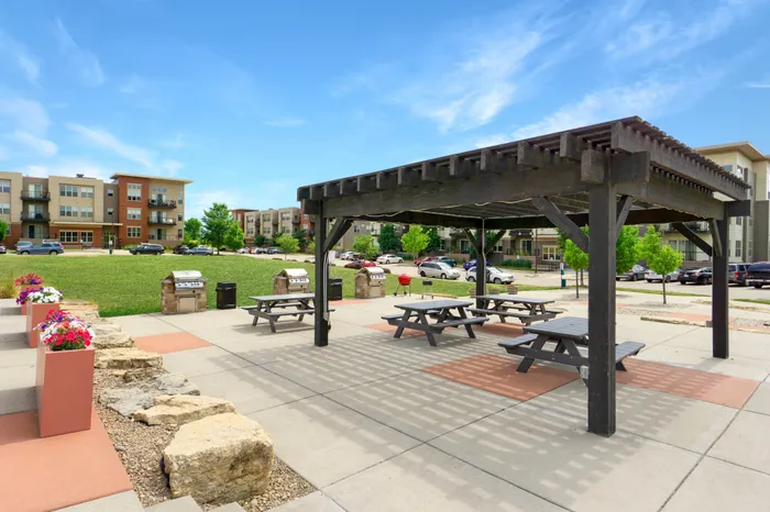 Outdoor courtyard with grilling, picnic areas, and fire pit at 50Twenty Apartments in Madison, Wisconsin.
