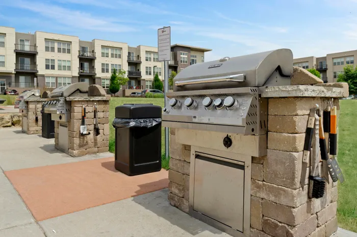 Outdoor courtyard with grilling, picnic areas, and fire pit at 50Twenty Apartments in Madison, Wisconsin.